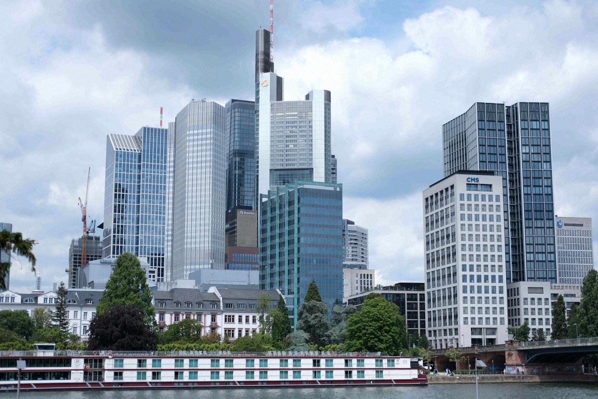 Die Wolkenkratzer des Frankfurter Bankenviertels mit dem Commerzbank Tower erheben sich hinter einem Ausflugsschiff auf dem Main